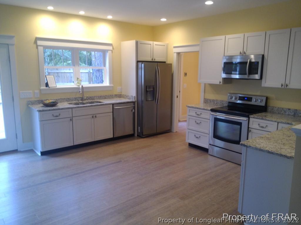 4015 Youngs Road Southern Pines, NC 28387 - Photo 4 of 25 a kitchen with stainless steel appliances granite countertop a stove a sink dishwasher a refrigerator and a microwave