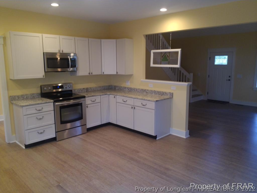 4015 Youngs Road Southern Pines, NC 28387 - Photo 5 of 25 a kitchen with stainless steel appliances granite countertop a stove a sink and a refrigerator