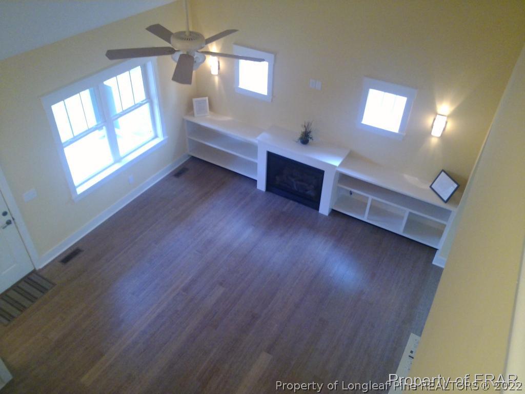 4015 Youngs Road Southern Pines, NC 28387 - Photo 9 of 25 wooden floor fireplace and windows in an empty room