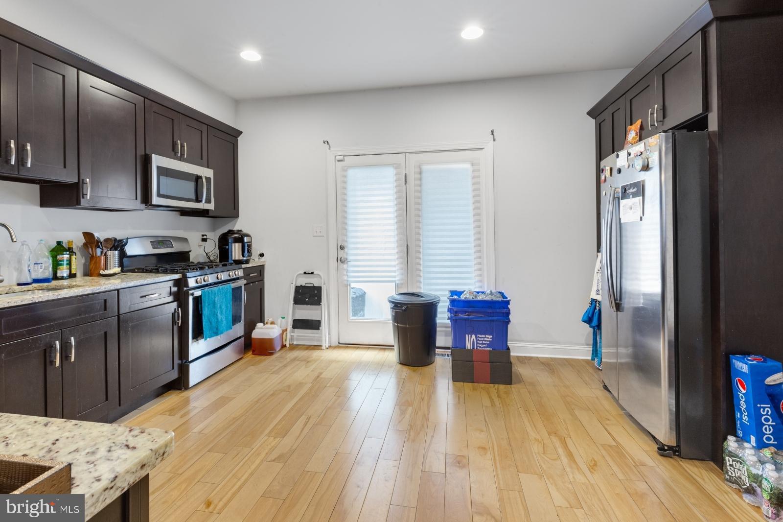 2629 Cedar Street Philadelphia, PA 19125 - Photo 5 of 30 a kitchen with stainless steel appliances wooden floors and wooden cabinets