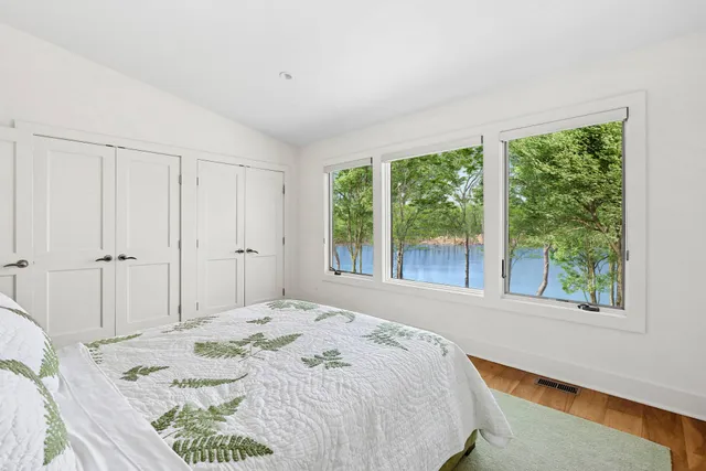 a bedroom with bed and a large window