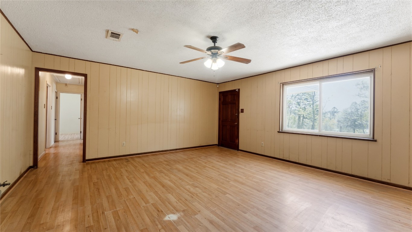 187 Watson Lake Road Huntsville, TX 77340 - Photo 11 of 25 a view of an empty room with wooden floor and a ceiling fan