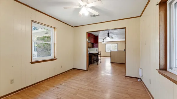 an empty room with windows and fan