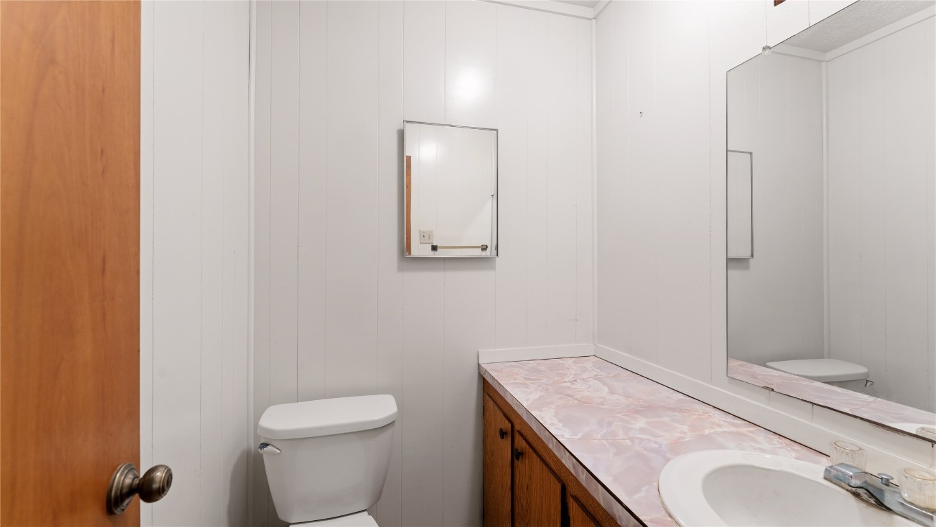 187 Watson Lake Road Huntsville, TX 77340 - Photo 19 of 25 a bathroom with a granite countertop toilet and a sink