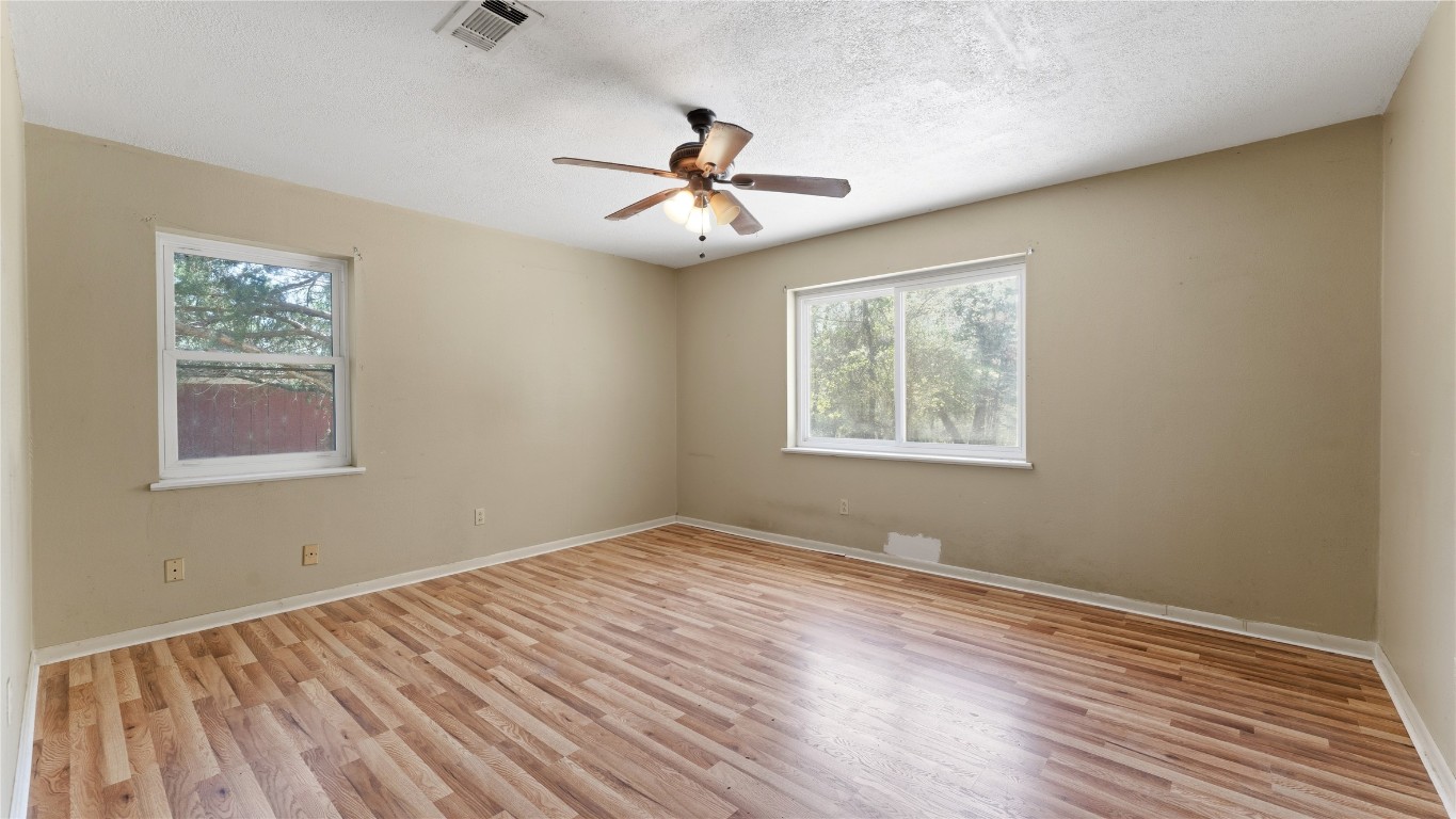 187 Watson Lake Road Huntsville, TX 77340 - Photo 20 of 25 a view of an empty room with wooden floor and a window