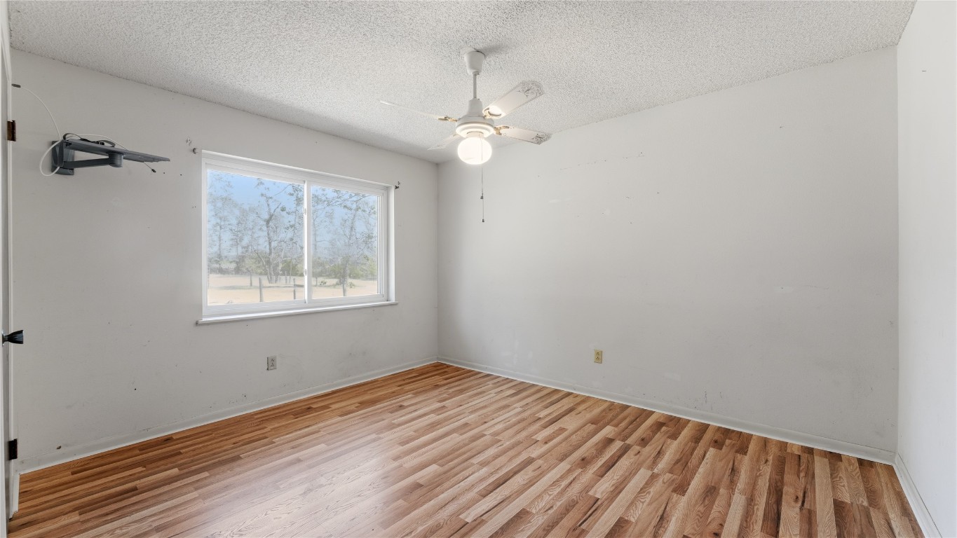 187 Watson Lake Road Huntsville, TX 77340 - Photo 22 of 25 wooden floor in an empty room with a window