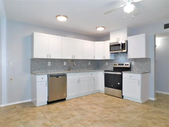 a kitchen with stainless steel appliances granite countertop a stove a sink and a refrigerator