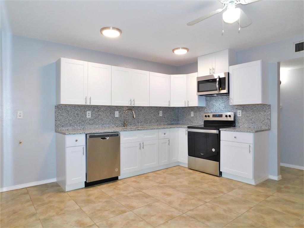 421 Shadowcrest Lane Coppell, TX 75019 - Photo 7 of 22 a kitchen with stainless steel appliances granite countertop a stove a sink and a refrigerator