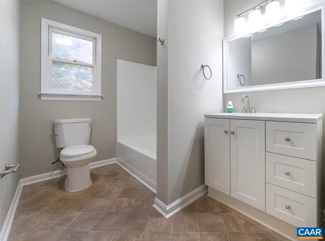 a bathroom with a toilet a sink and a mirror