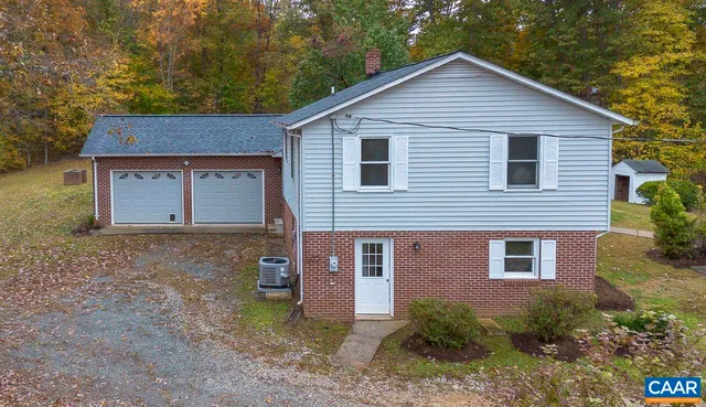 a view of a house with a yard and large tree