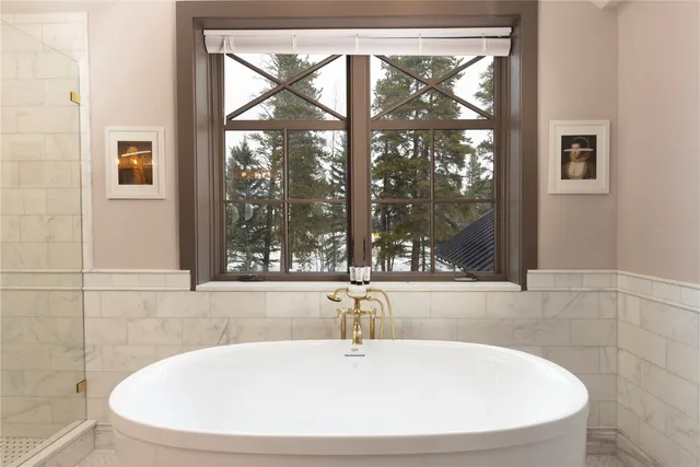 a white bath tub sitting in a bathroom next to a window
