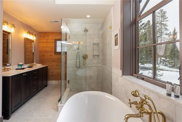 a bathroom with a tub sink shower and mirror