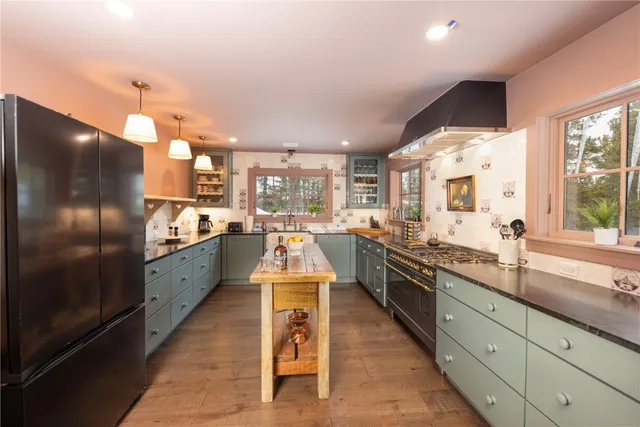 a large kitchen with kitchen island granite countertop lots of counter top space a sink and stainless steel appliances