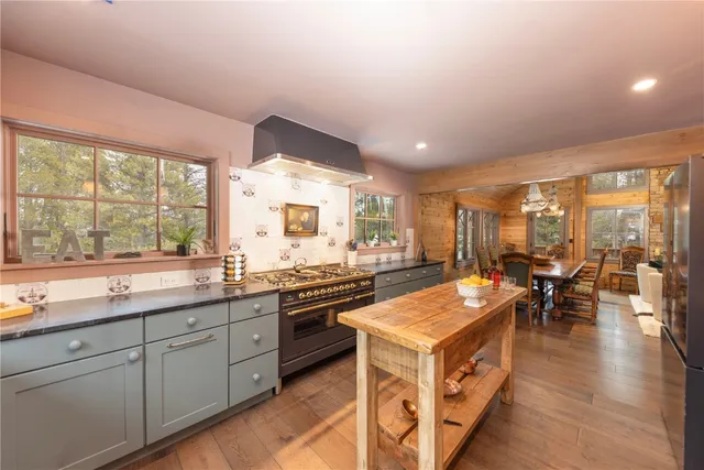 a large kitchen with stainless steel appliances granite countertop a stove and a view of living room