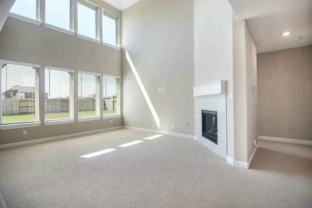 a view of an empty room with a fireplace and a window