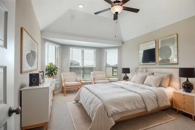 a bedroom with a large bed a flat screen tv and a couch