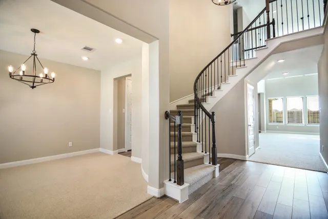 a view of a hallway with wooden floor and staircase