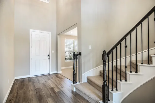 a view of a hallway with wooden floor and staircase
