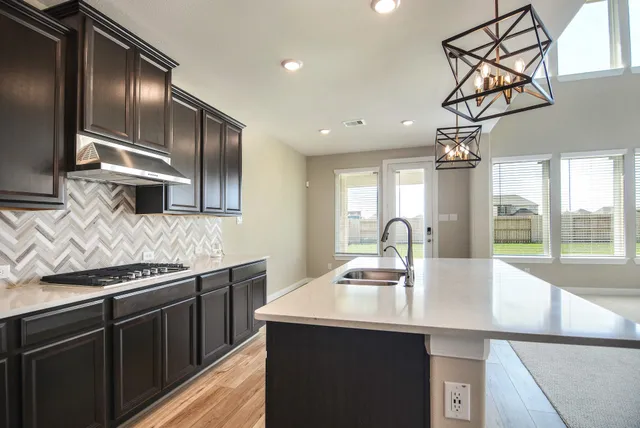 a kitchen with stainless steel appliances a sink a stove and a refrigerator