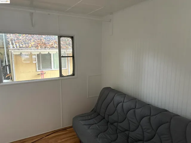 a view of a small space with wooden floor and a window