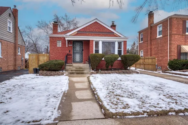 a front view of a house with a yard and potted plants