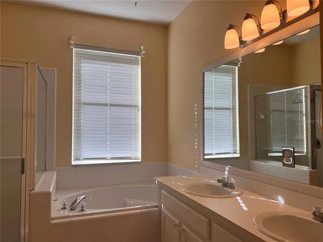 a bathroom with a granite countertop sink mirror and a bathtub
