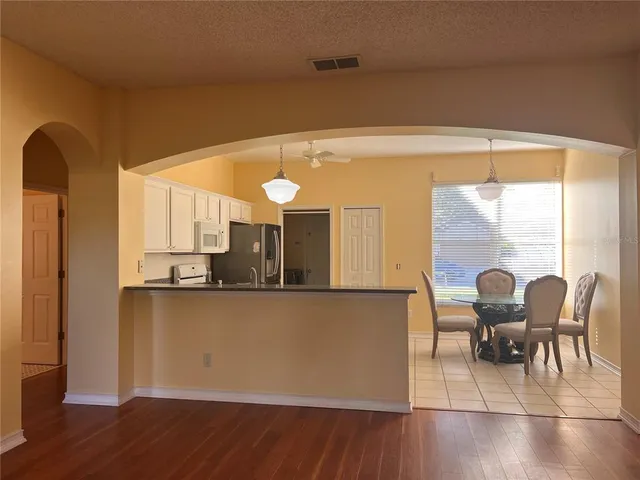 a living room with stainless steel appliances kitchen island granite countertop furniture and a large window