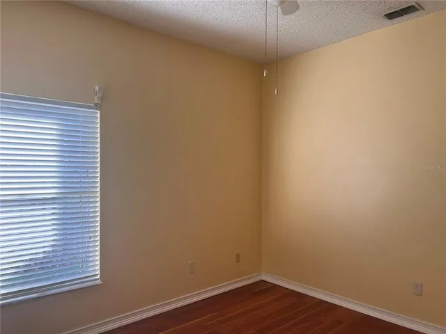 a view of a small space with wooden floor and a window