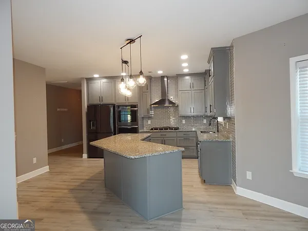 a large kitchen with kitchen island a sink stainless steel appliances and cabinets