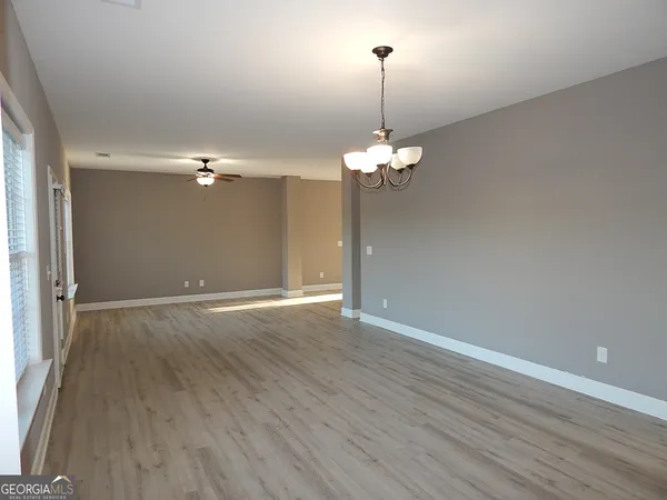 a view of an empty room with wooden floor