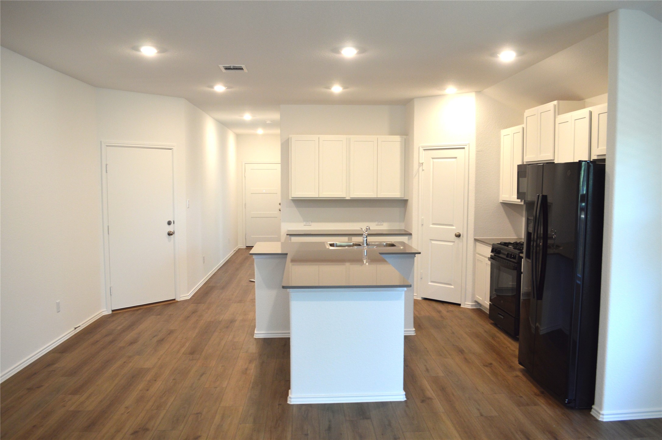1524 Marley Kyle, TX 78640 - Photo 3 of 22 Kitchen featuring black appliances, white cabinets, an island with sink, dark wood finished floors, and recessed lighting