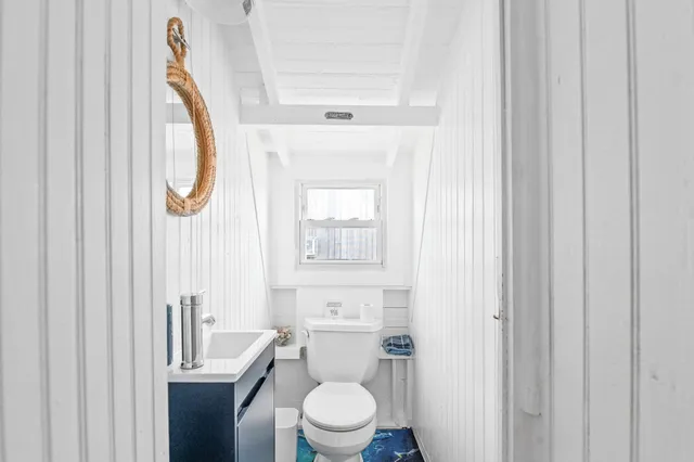 a white toilet sitting next to a bathroom sink