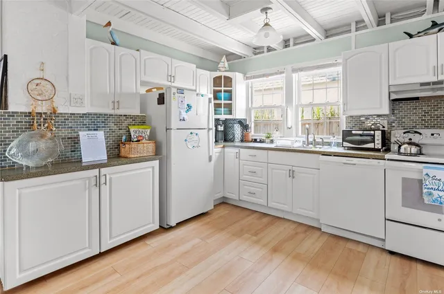 a kitchen with white cabinets and white appliances