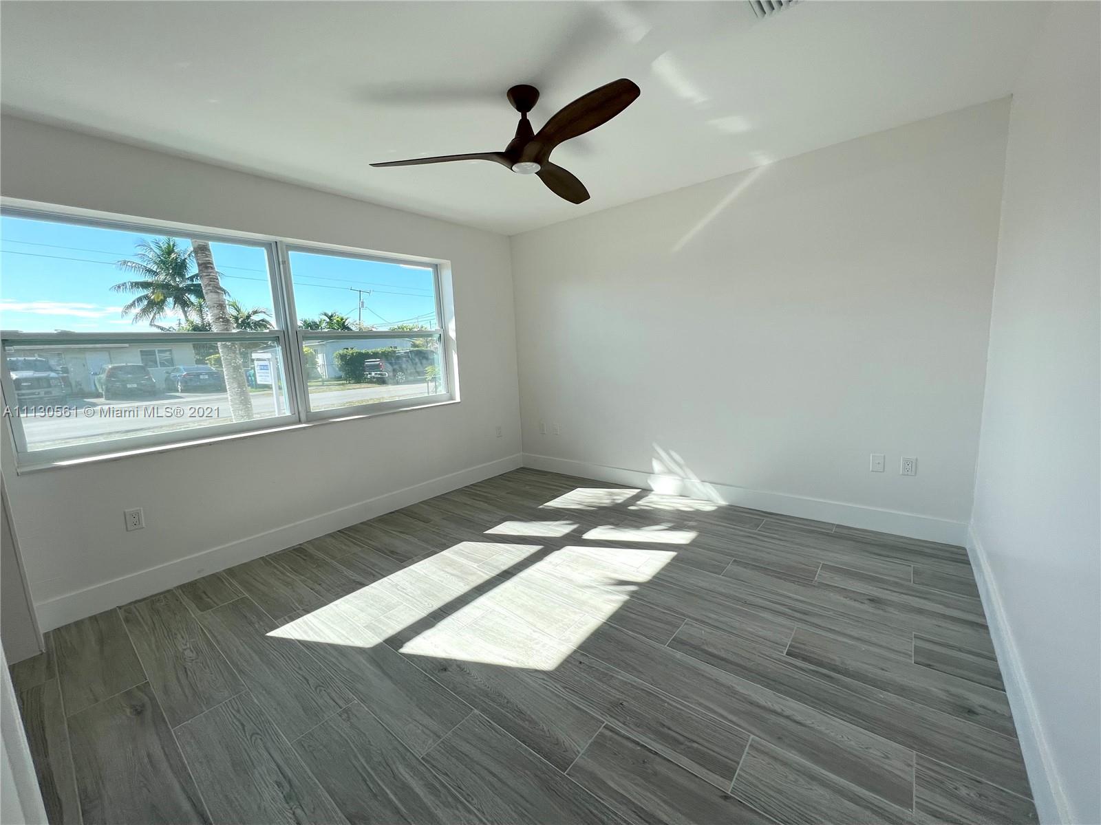 8935 Southwest 38th Street Miami, FL 33165 - Photo 11 of 24 wooden floor in an empty room with a window