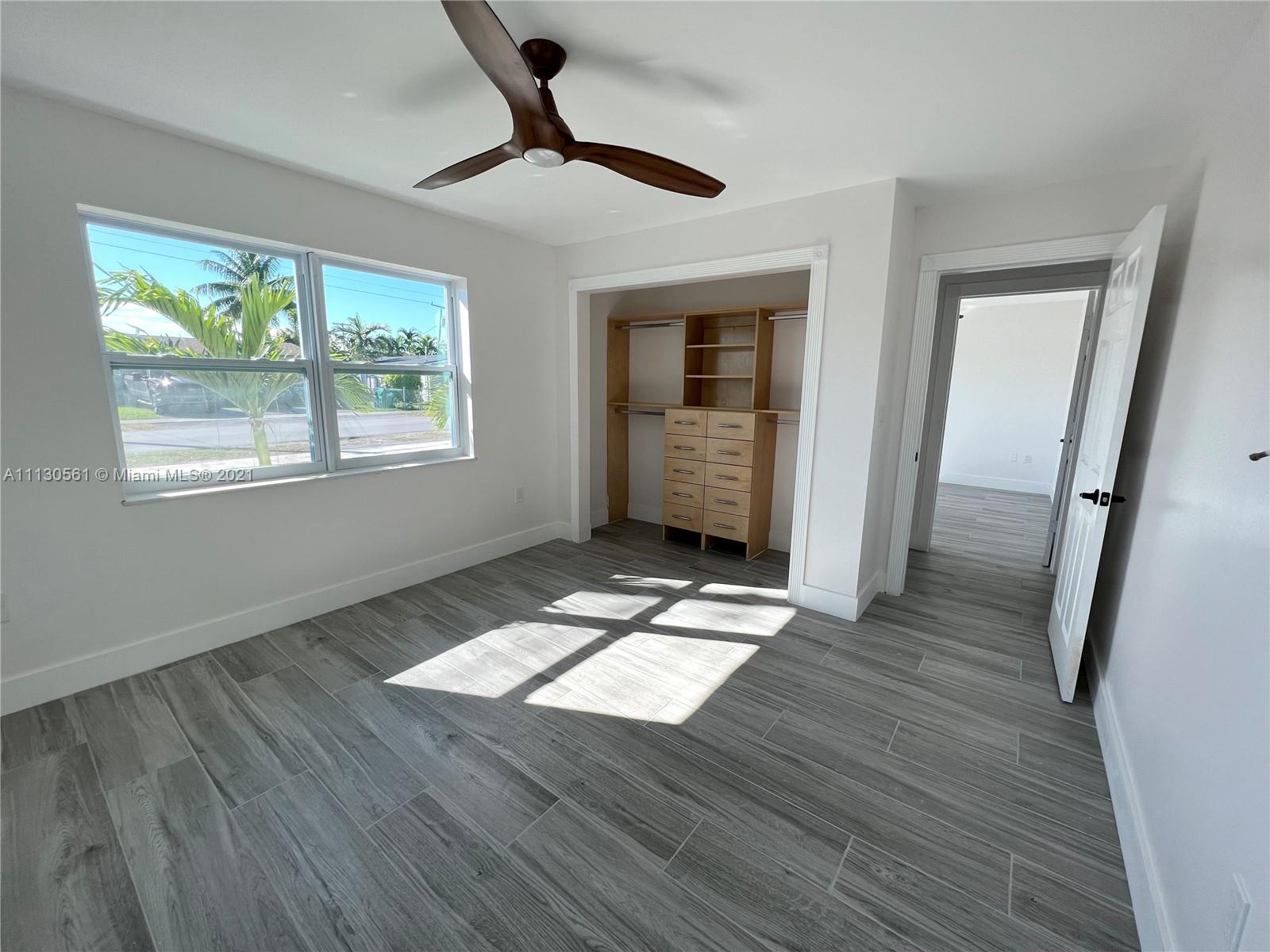 8935 Southwest 38th Street Miami, FL 33165 - Photo 12 of 24 wooden floor in an empty room with a window