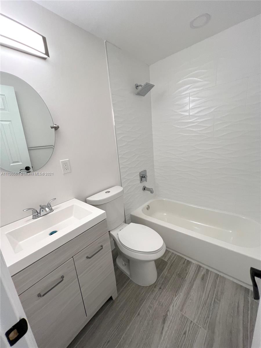 8935 Southwest 38th Street Miami, FL 33165 - Photo 13 of 24 a bathroom with a double vanity sink a toilet and bathtub