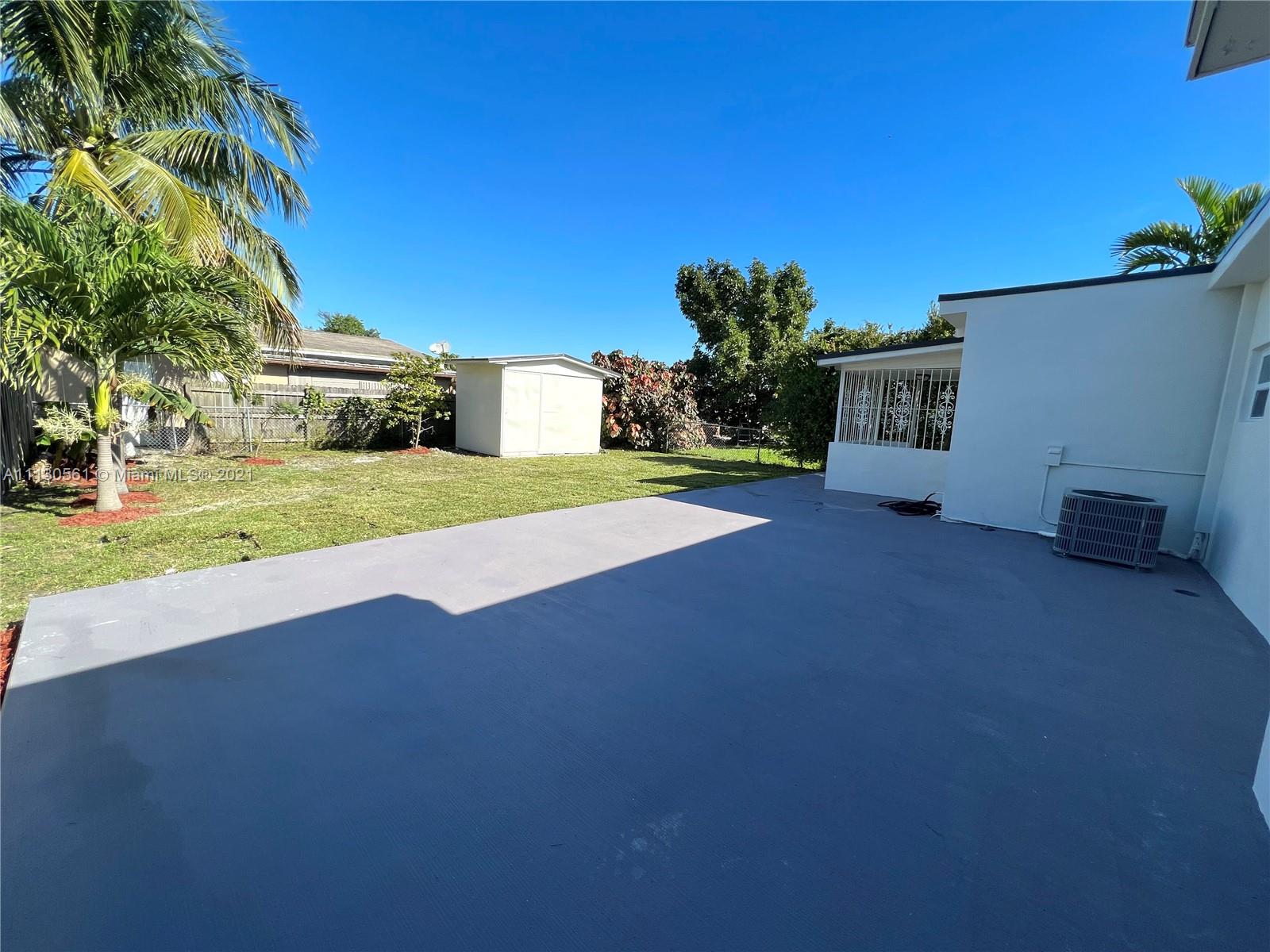 8935 Southwest 38th Street Miami, FL 33165 - Photo 18 of 24 a view of a house with a yard and garage