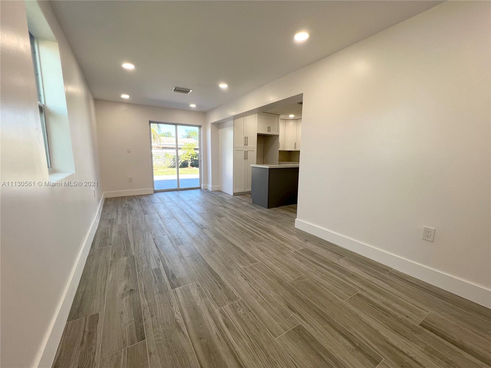 8935 Southwest 38th Street Miami, FL 33165 - Photo 3 of 24 a view of empty room with wooden floor and window