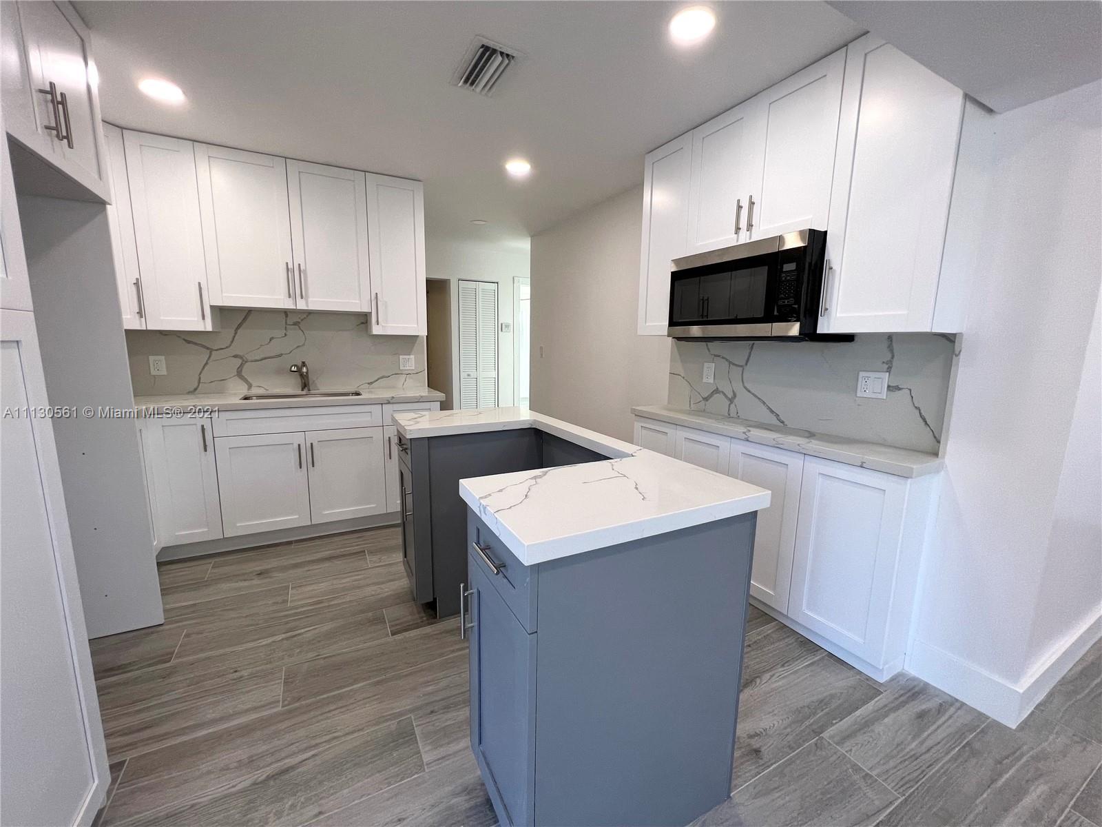 8935 Southwest 38th Street Miami, FL 33165 - Photo 5 of 24 a kitchen with a sink a microwave and cabinets