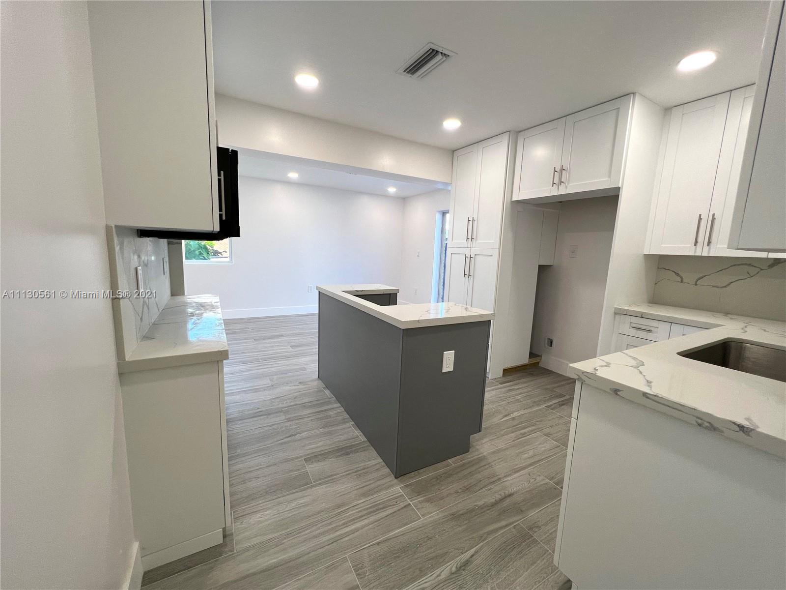 8935 Southwest 38th Street Miami, FL 33165 - Photo 8 of 24 a large kitchen with stainless steel appliances kitchen island a large counter top a sink a stove and a refrigerator