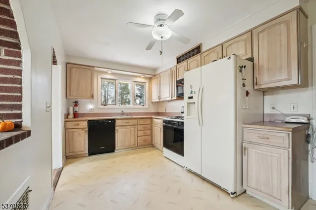 a kitchen with a refrigerator a sink stainless steel appliances and cabinets