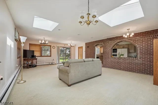 a living room with furniture chandelier and a flat screen tv