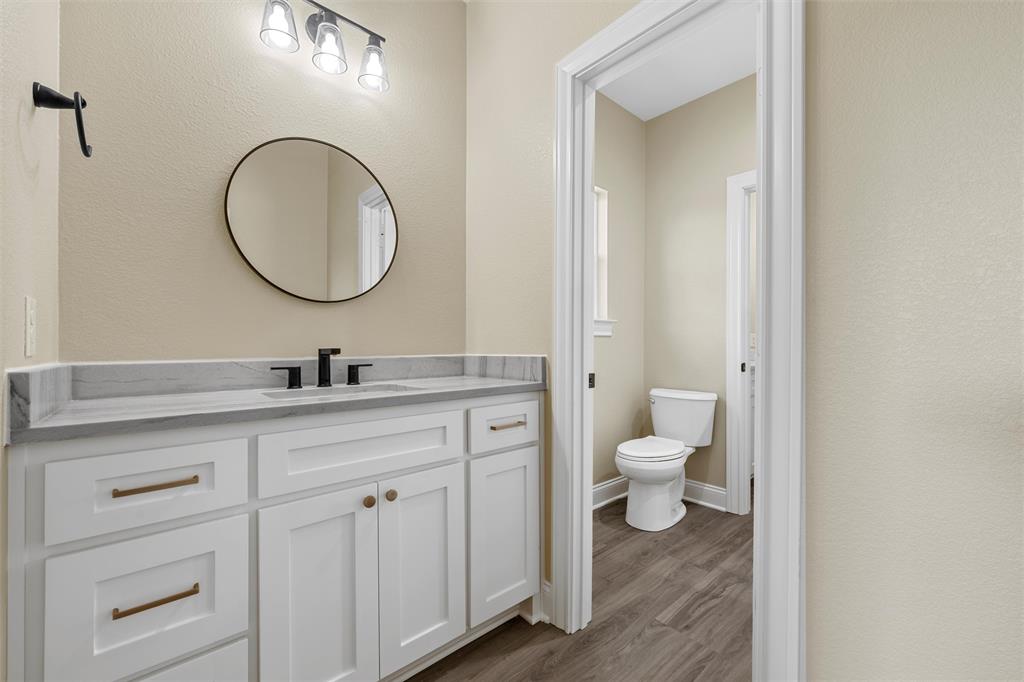 929 Northern Dancer Drive Hewitt, TX 76643 - Photo 23 of 36 a bathroom with a granite countertop toilet a sink and a mirror