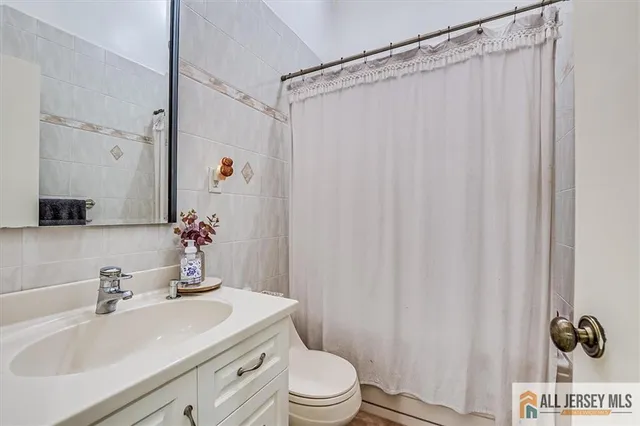 a bathroom with a sink a toilet and shower curtain