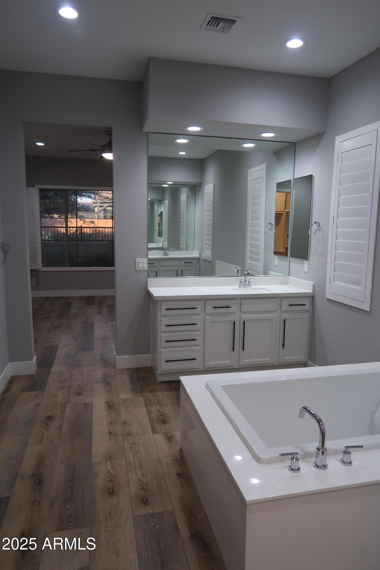 2852 East Robin Lane Phoenix, AZ 85050 - Photo 15 of 58 a bathroom with a sink a large mirror and a bathtub