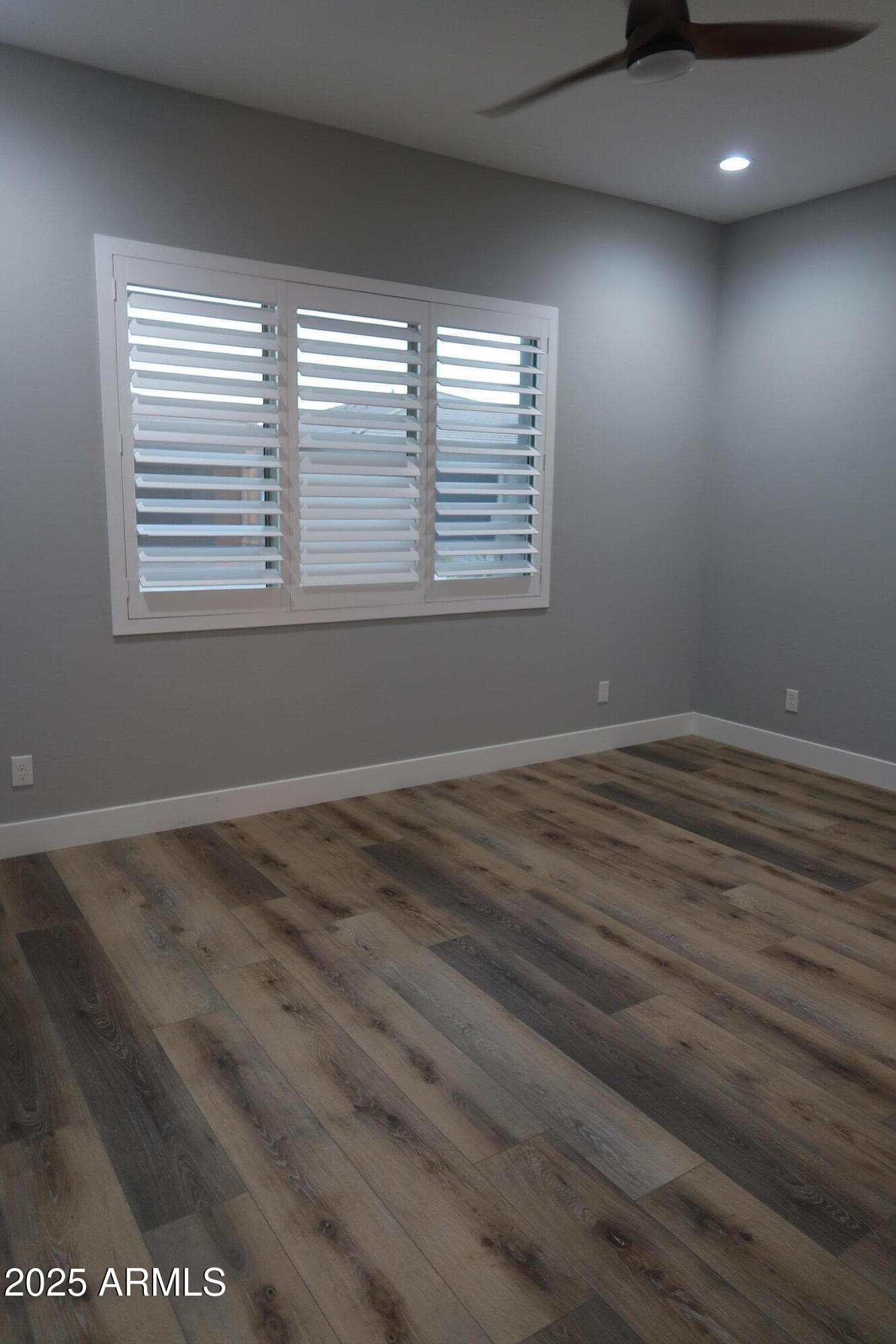 2852 East Robin Lane Phoenix, AZ 85050 - Photo 17 of 58 an empty room with wooden floor and windows