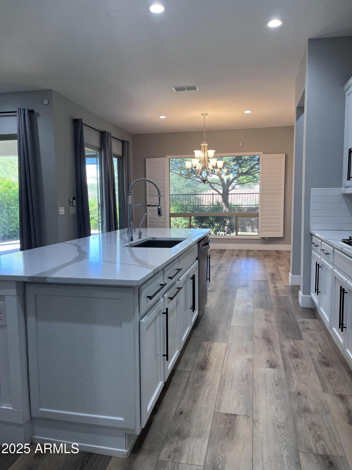 2852 East Robin Lane Phoenix, AZ 85050 - Photo 5 of 58 a large kitchen with stainless steel appliances a large counter top a sink a stove and a wooden floors