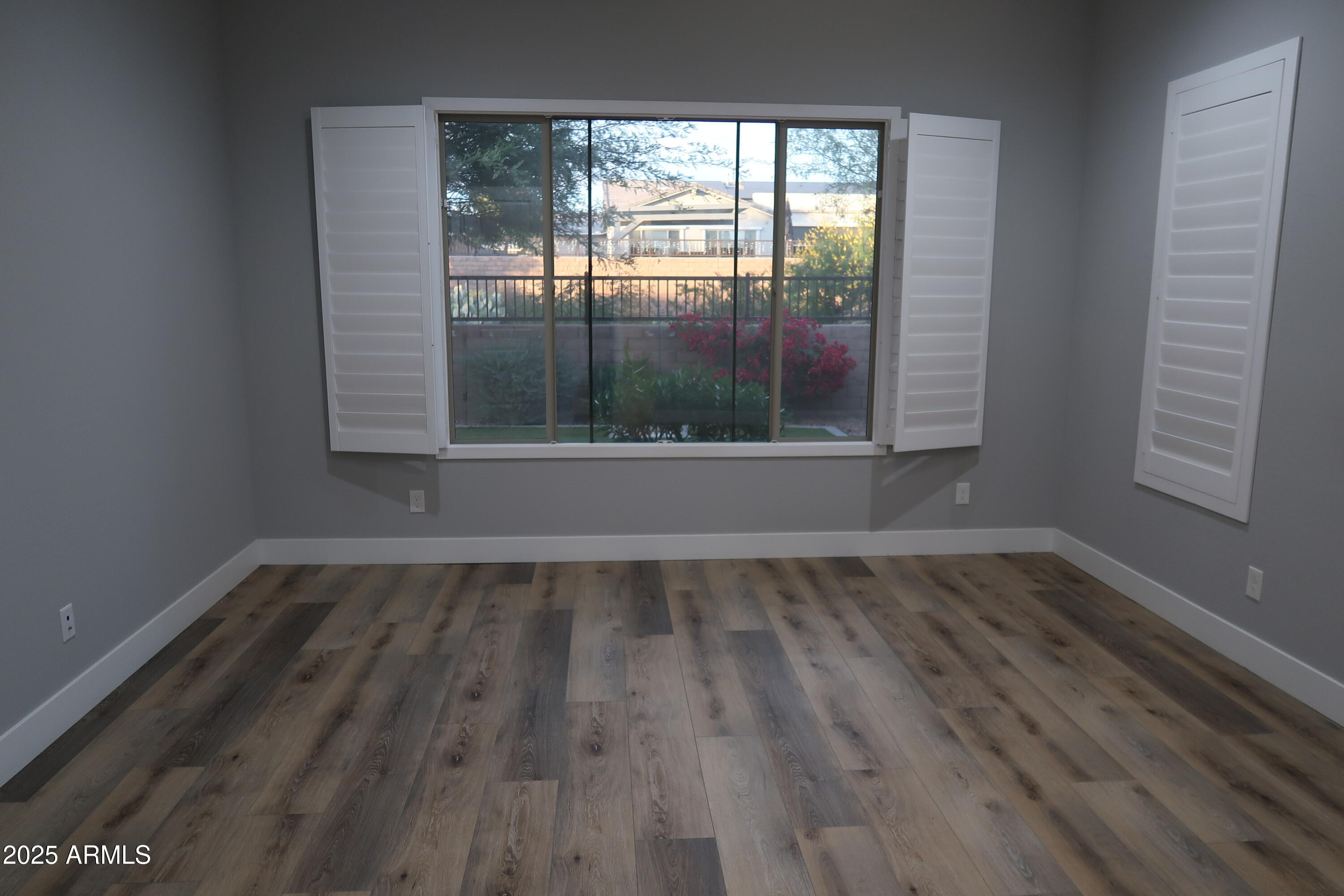 2852 East Robin Lane Phoenix, AZ 85050 - Photo 10 of 58 a view of an empty room with wooden floor and a window