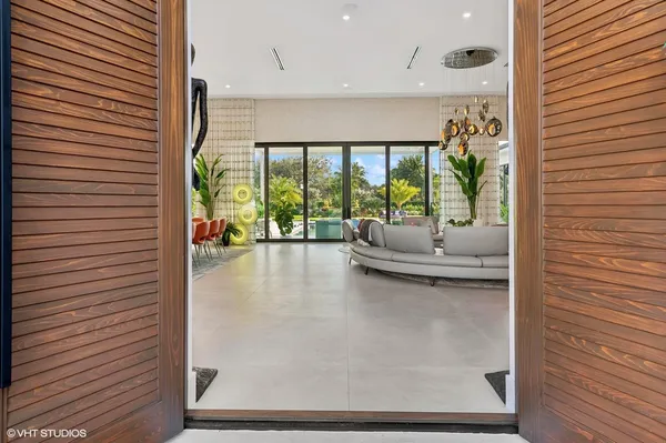a living room with patio furniture and a large window