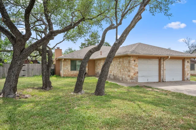 a view of a house with a yard and tree